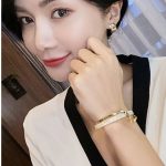 Armband aus weißem Muschelplättchen mit gebogenen Handornamenten aus Metall – Bild 6